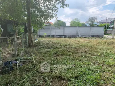 Vacant land plot with lush greenery and potential for development in a serene neighborhood.