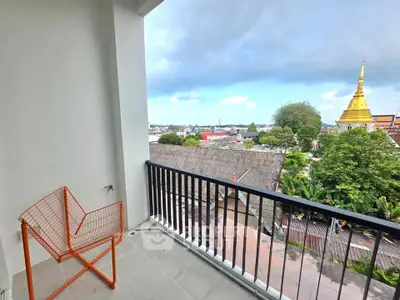 Charming balcony with city view and unique orange chair, perfect for relaxation and enjoying the skyline.
