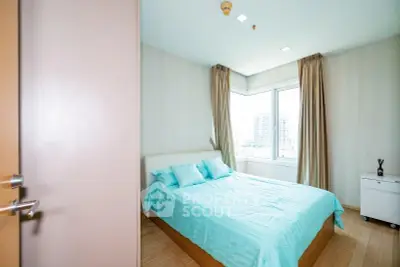 Bright bedroom with large window and modern decor in urban apartment