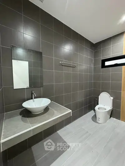 Modern bathroom with sleek gray tiles and contemporary fixtures.
