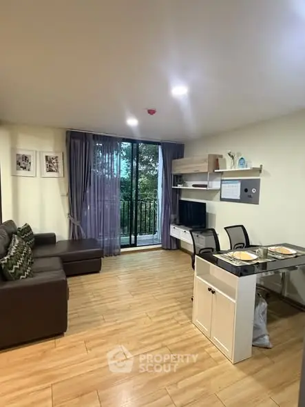 Modern living room with balcony view, featuring stylish furniture and open layout.