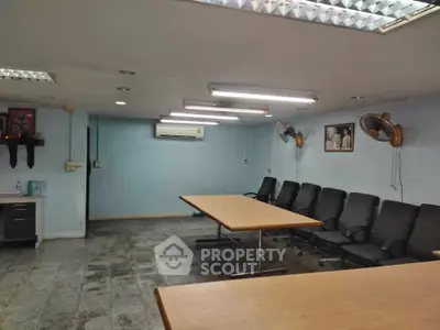 Spacious office meeting room with conference table and chairs, ideal for business gatherings.