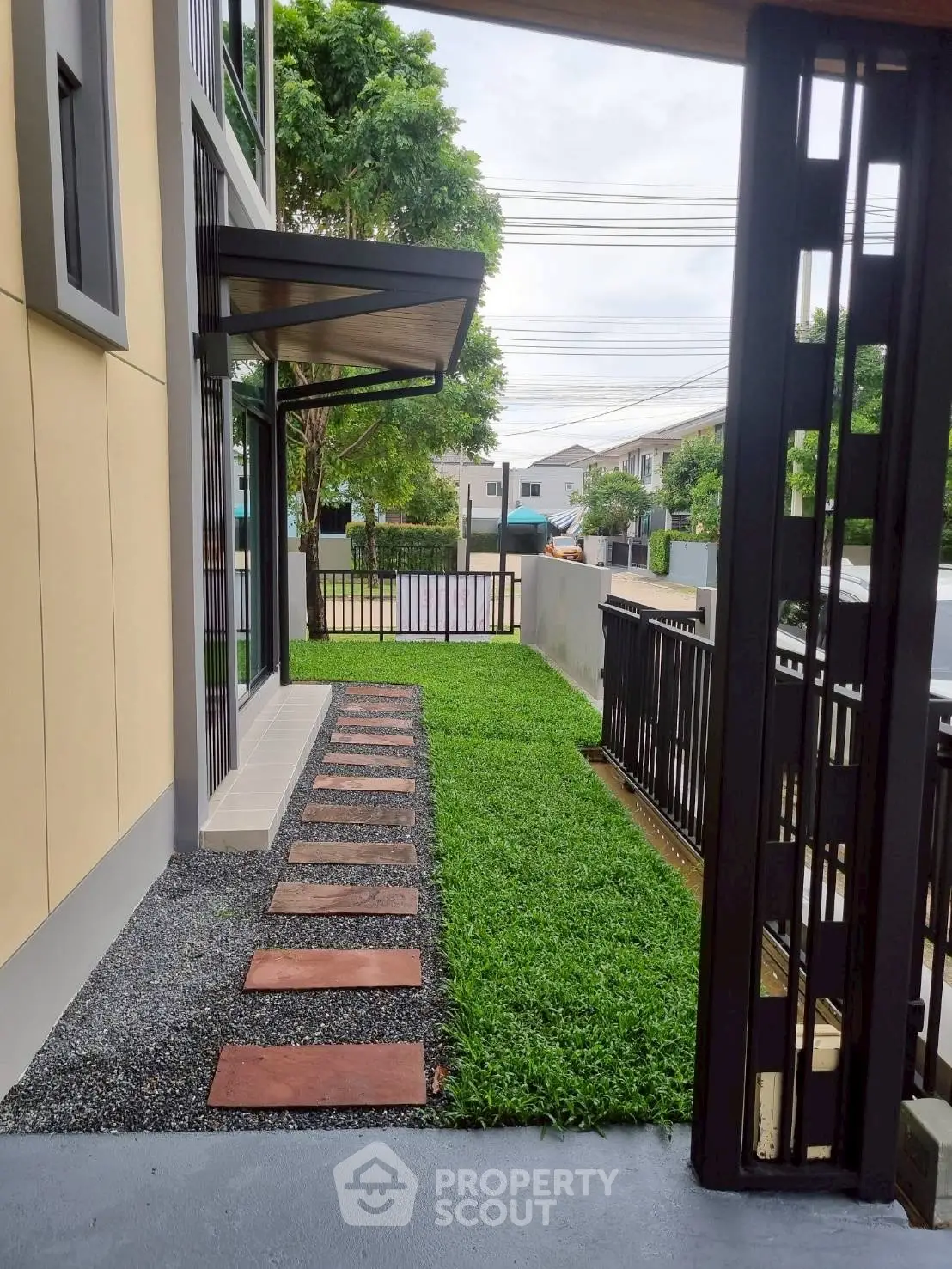 Charming modern home exterior with lush green garden and pathway
