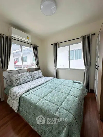 Cozy bedroom with large windows and elegant curtains, featuring a comfortable bed and modern air conditioning.