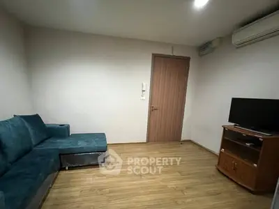 Cozy living room with modern sofa and TV setup, perfect for relaxation.