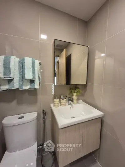 Modern bathroom with sleek vanity and stylish decor in a contemporary apartment.