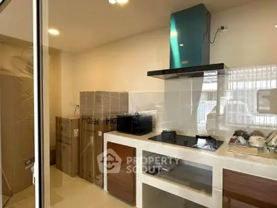 Modern kitchen with sleek appliances and ample storage space, featuring a gas stove and contemporary design.