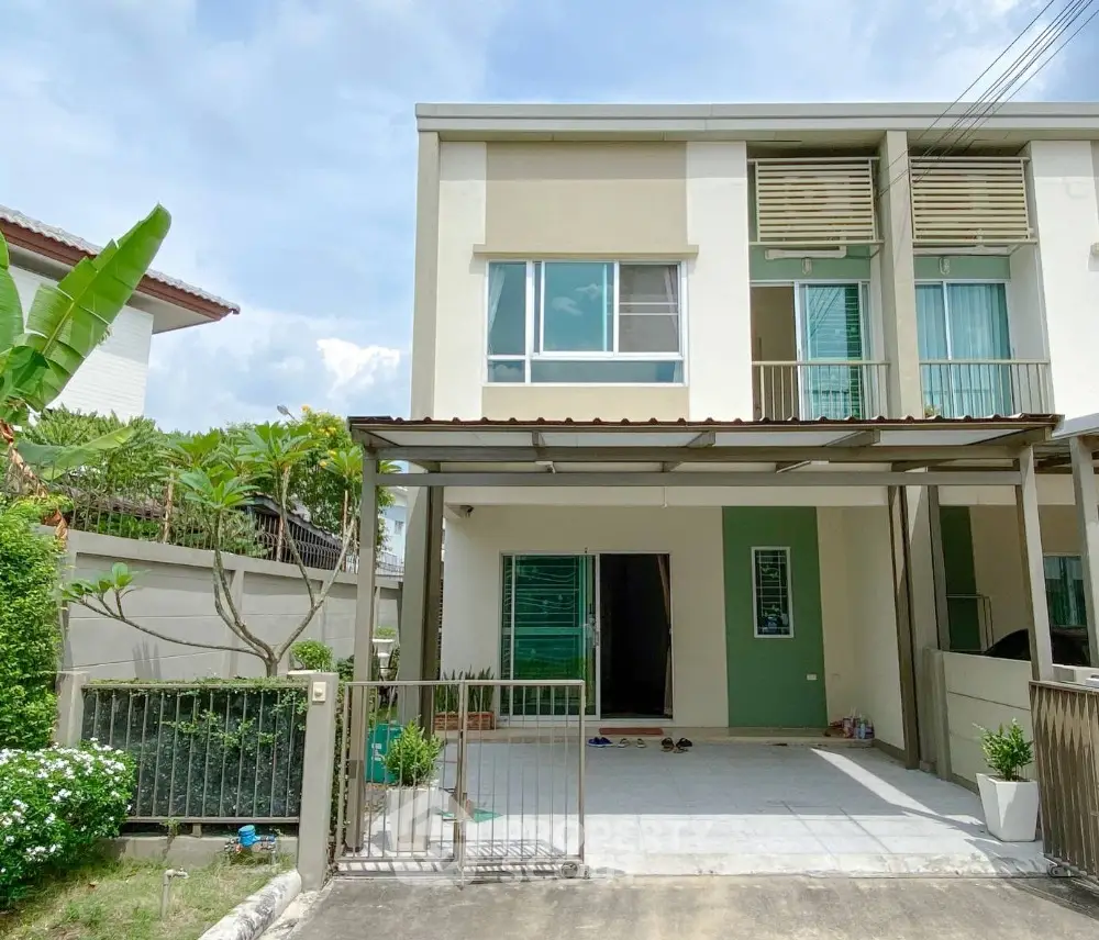 Charming two-story house with spacious carport and lush garden view