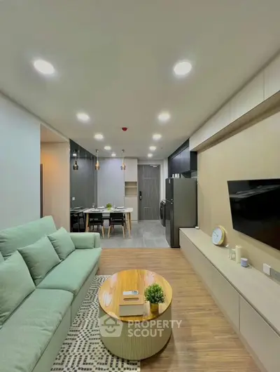 Modern living room with sleek design, featuring a cozy sofa, wall-mounted TV, and stylish dining area.