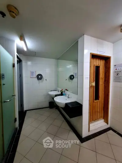 Modern bathroom with dual sinks and sauna in luxury real estate property.