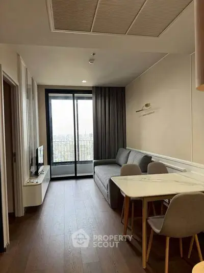 Modern living room with balcony view, featuring sleek furniture and elegant decor.
