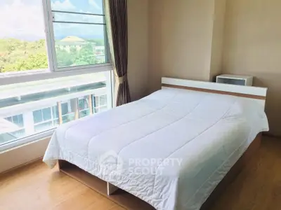 Bright bedroom with large window offering scenic views and modern furnishings.