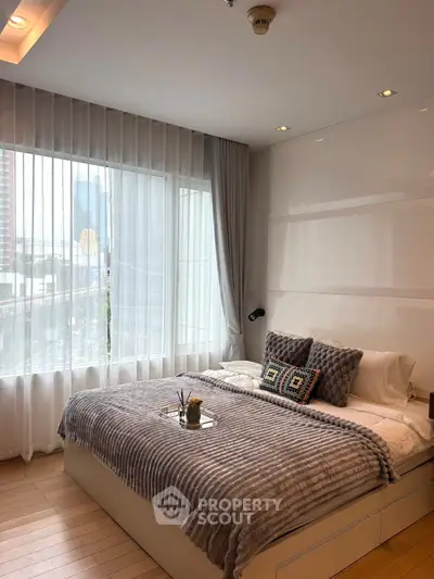 Modern bedroom with large window and stylish decor in urban apartment