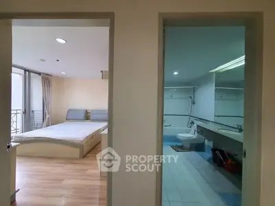 Spacious bedroom with adjacent modern bathroom in a well-lit apartment.