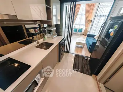 Modern open-layout kitchen with sleek appliances and view into stylish living room