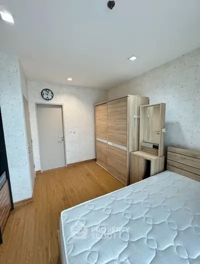 Spacious bedroom with wooden flooring and ample closet space in modern apartment.