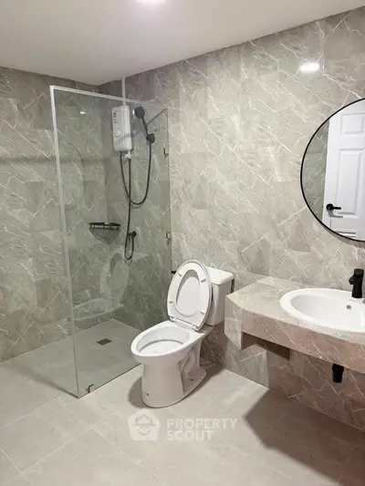 Modern bathroom with glass shower and marble tiles