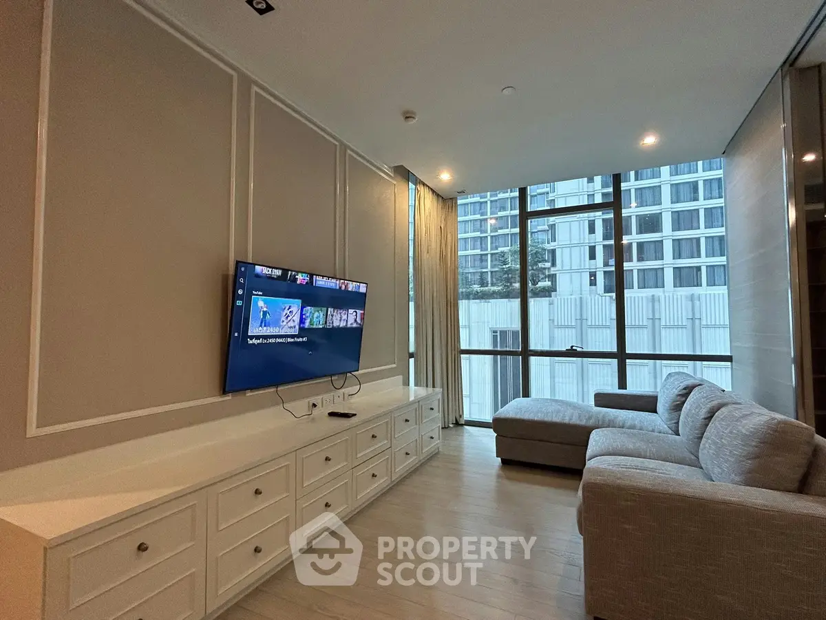 Modern living room with large windows and stylish furniture in a high-rise apartment.