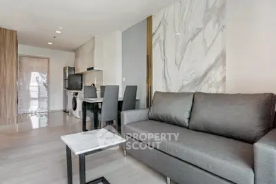 Modern living room with sleek furniture and marble accent wall in a stylish apartment.