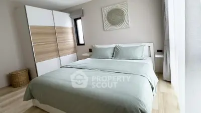 Modern bedroom with stylish decor and ample natural light, featuring a cozy bed and sleek wardrobe.