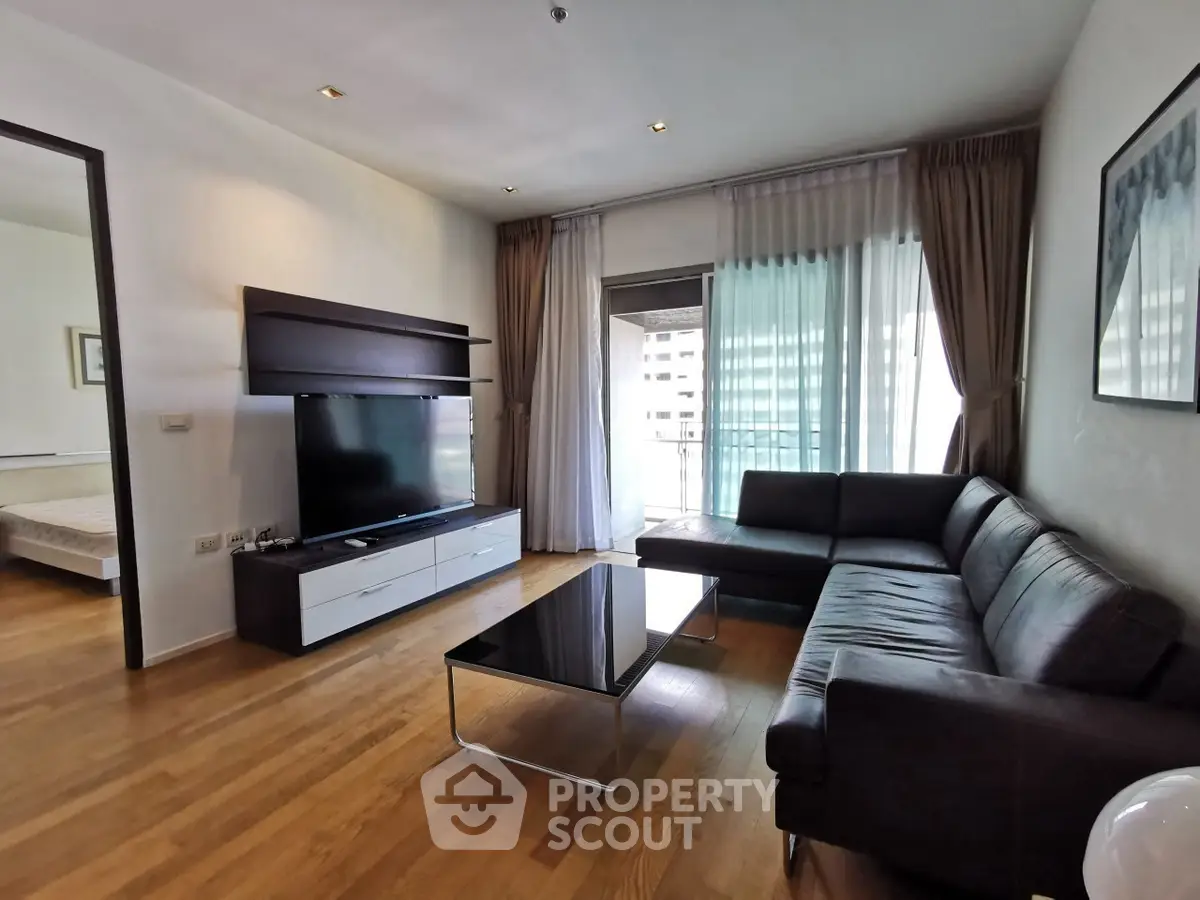Spacious modern living room with sleek furniture and large windows offering natural light.