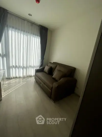 Cozy living room with natural light and modern sofa in a stylish apartment.