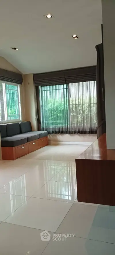 Spacious living room with large windows and modern seating area.