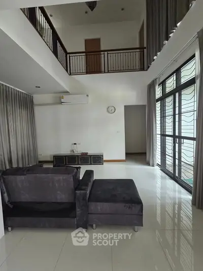 Spacious modern living room with high ceilings and large windows for natural light.