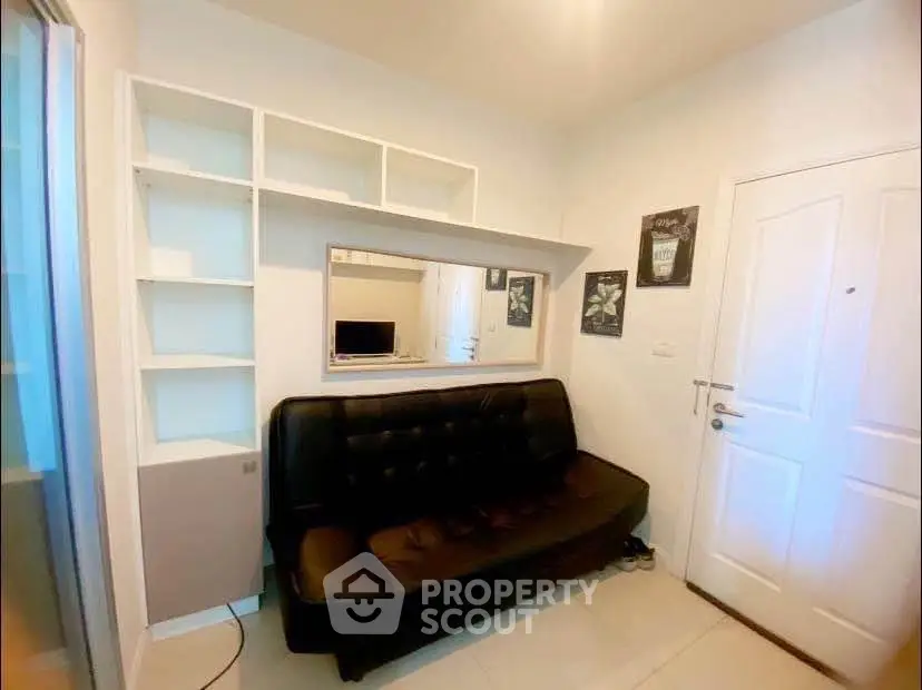 Cozy living room with black leather sofa and built-in shelving