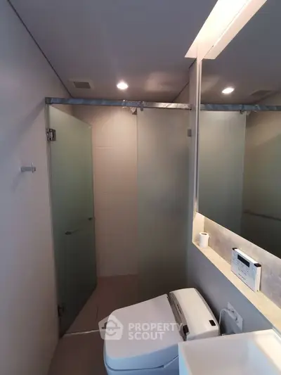 Modern bathroom with frosted glass shower and sleek fixtures