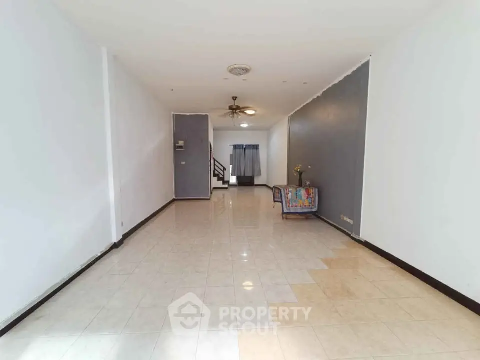 Spacious open-plan living area with tiled flooring and neutral walls, ideal for customization.