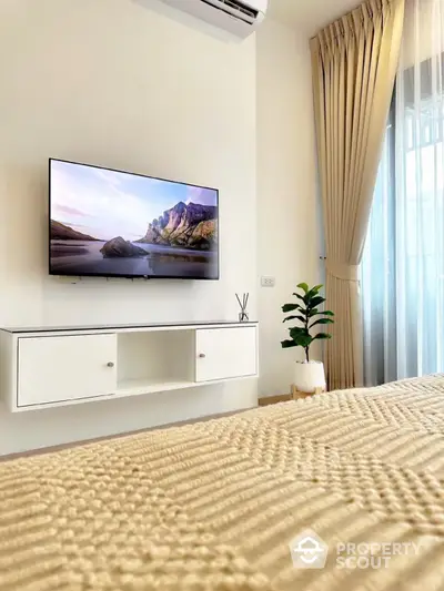 Modern bedroom with wall-mounted TV and elegant decor