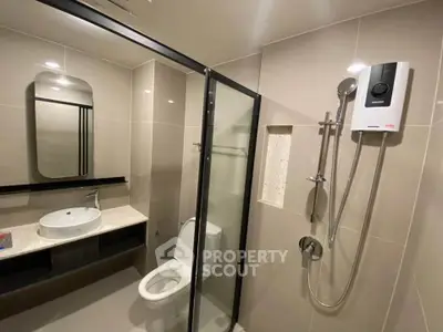 Modern bathroom with sleek shower and stylish vanity in contemporary apartment.