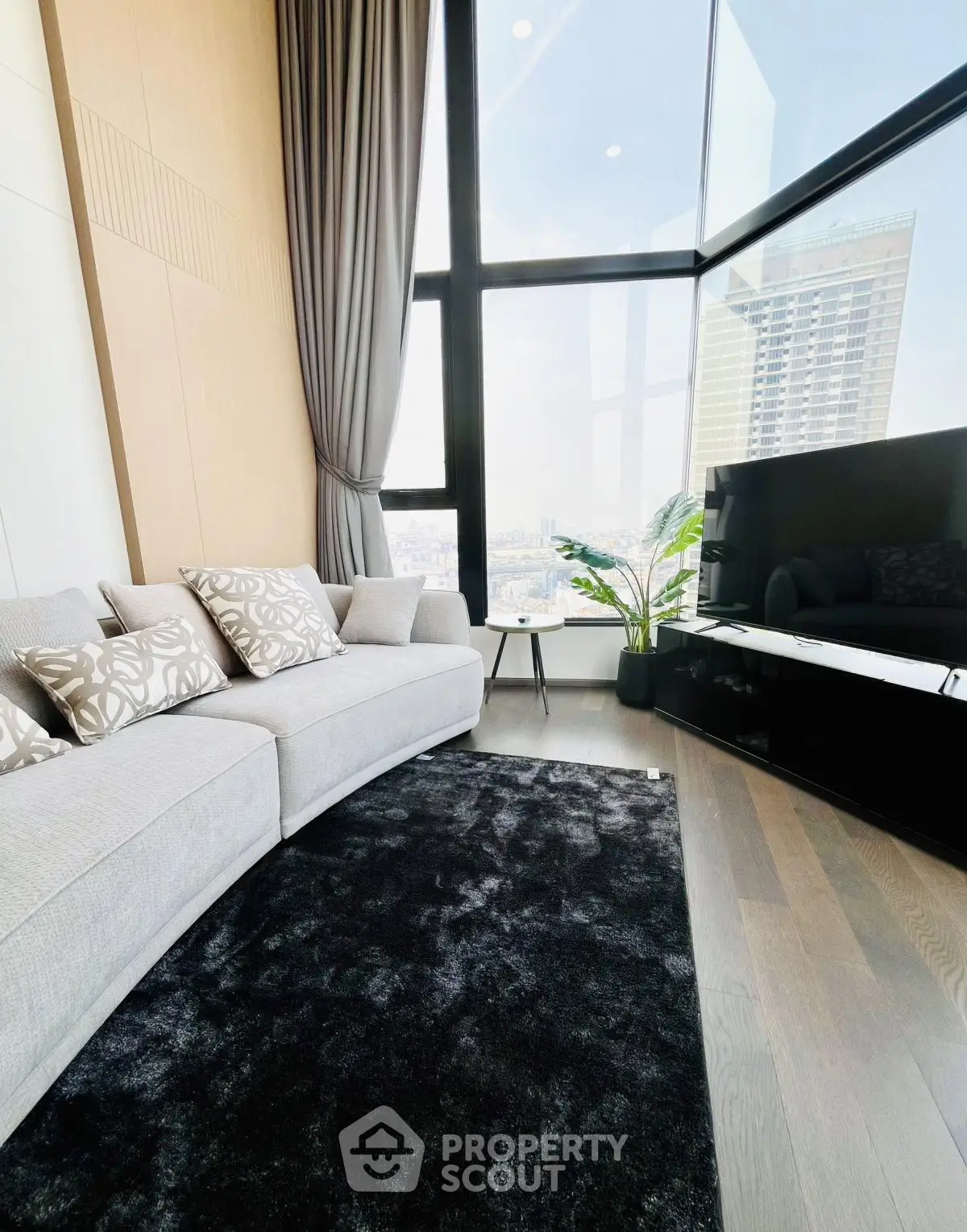 Luxurious modern living room with floor-to-ceiling windows and stunning city views.
