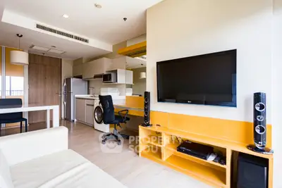 Modern living room with integrated kitchen, featuring sleek furniture and entertainment setup.