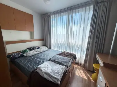 Cozy bedroom with large window and modern furnishings, perfect for natural light lovers.