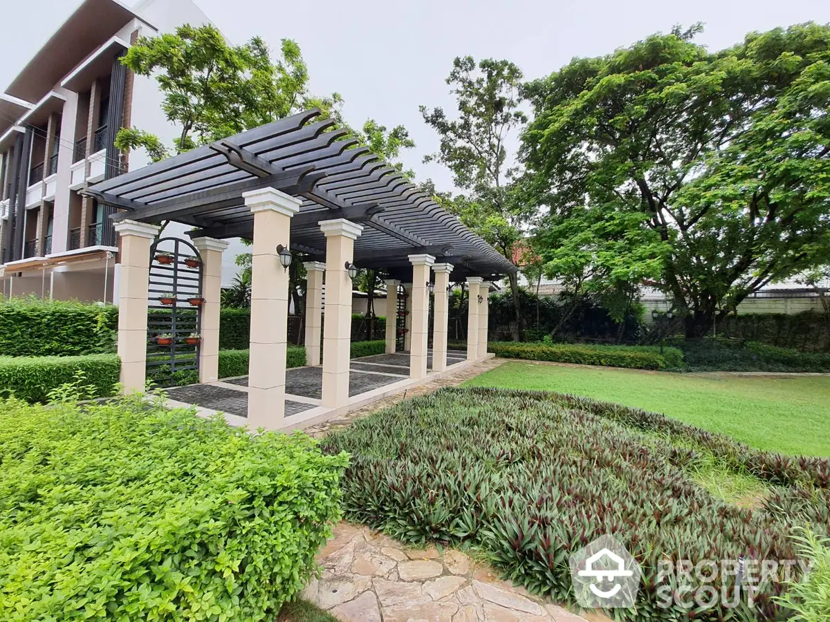 Elegant outdoor gazebo surrounded by lush greenery and manicured gardens, offering a serene space for relaxation and entertainment.