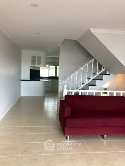 Spacious living room with modern staircase and open kitchen layout