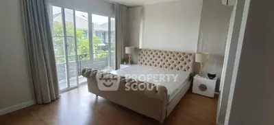 Spacious bedroom with elegant bed and large windows offering natural light