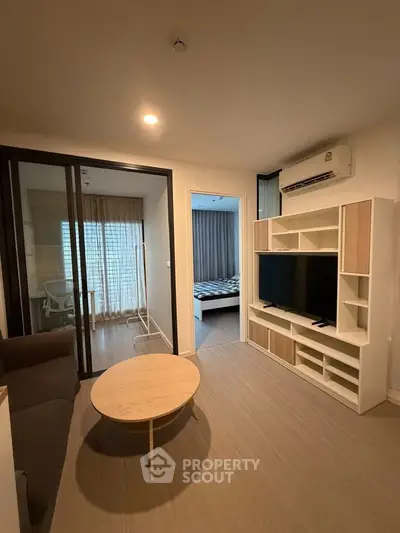 Modern living room with sliding glass doors and stylish furniture in a cozy apartment.