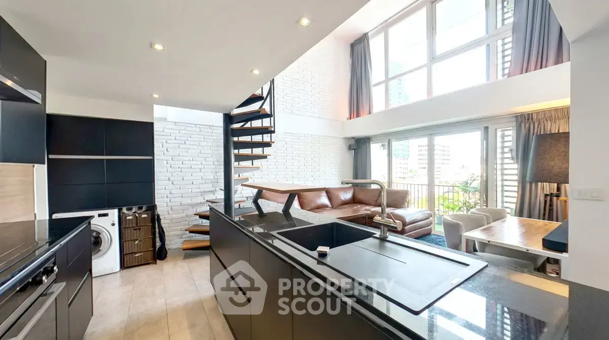 Modern duplex living room with spiral staircase and large windows, featuring sleek kitchen and cozy seating area.