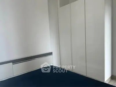 Modern minimalist bedroom with sleek white wardrobe and stylish bed.