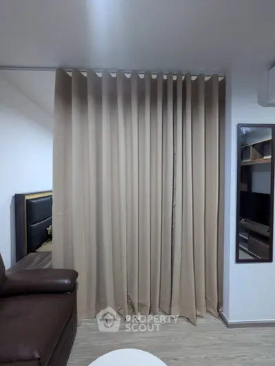 Cozy living room with brown leather sofa and elegant beige curtains