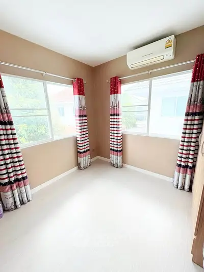 Bright bedroom with large windows and air conditioning in modern home