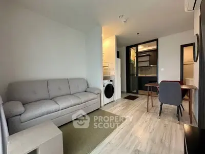 Modern living room with cozy sofa and dining area in open layout apartment.