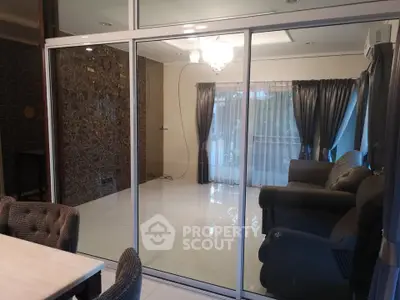 Spacious living room with glass partition and elegant furnishings in modern home