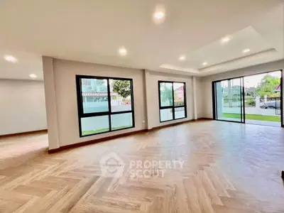 Spacious modern living room with large windows and elegant wooden flooring