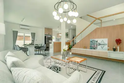 Modern open-plan living room with stylish decor and elegant staircase