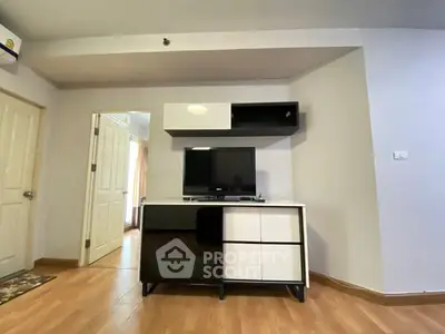 Modern living room with sleek TV stand and wall-mounted storage in a cozy apartment.