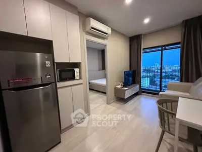 Modern apartment interior with open kitchen and city view, featuring sleek furniture and contemporary design.